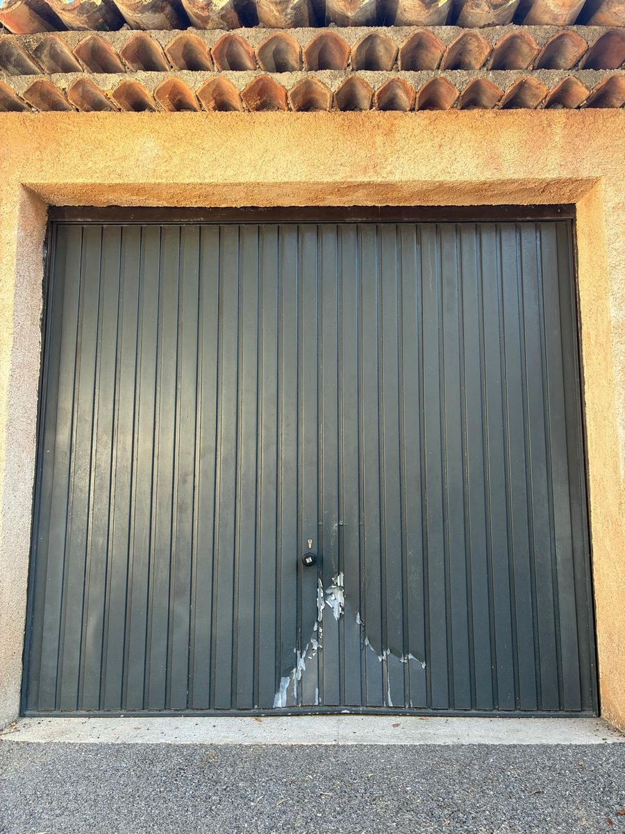 Ancienne porte de garage basculante verte avec peinture écaillée